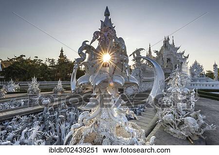 Stock Image - "Wat Rong Khun Temple or White Temple, a Buddhist-Hindu temple, backlit, sculptures depicting hell, Chiang Rai, northern Thailand, Thailand, Asia". Fotosearch
