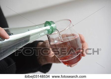"Water being poured from a bottle into a glass, France, Europe" View Large Photo Image Picture - "Water being poured from a bottle into a glass, France, Europe". Fotosearch