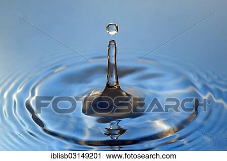 Stock Image - Water droplets falling onto water surface. Fotosearch