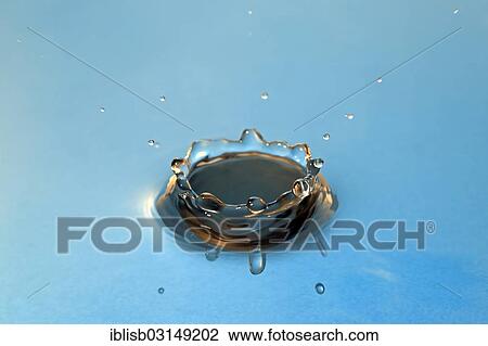 Stock Image - Water droplets falling onto water surface. Fotosearch
