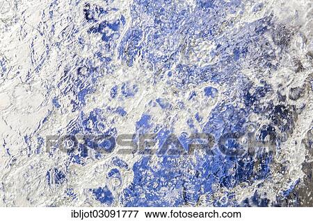 Stock Photo - "Water running down a sheet of glass, symbolic image for water consumption, wasting water". Fotosearch