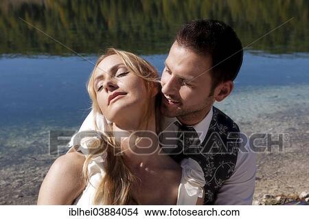 "Wedding couple, portrait, in front of a lake" View Large Photo Image Picture - "Wedding couple, portrait, in front of a lake". Fotosearch