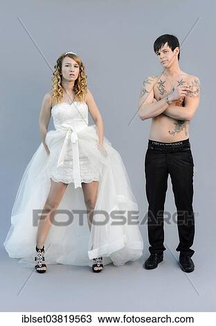 "Wedding picture, a bride in a short dress and a bare chested groom with tattoos, holding a cigarette" View Large Photo Image Stock Image - "Wedding picture, a bride in a short dress and a bare chested groom with tattoos, holding a cigarette". Fotosearch