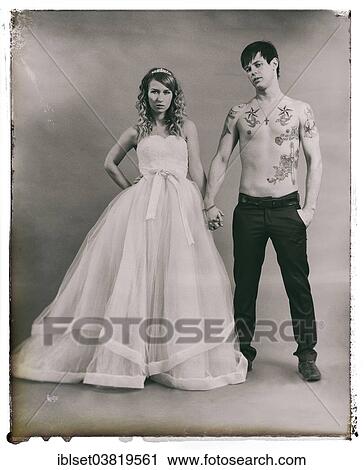 Stock Image - "Wedding picture, bride and groom, bare chested groom with tattoos". Fotosearch