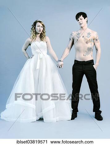 Stock Image - "Wedding picture, bride and groom, bare chested groom with tattoos". Fotosearch