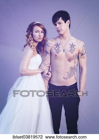 Stock Image - "Wedding picture, bride and groom, bare chested groom with tattoos". Fotosearch