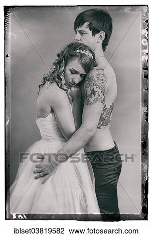 Stock Image - "Wedding picture, bride and groom, bare chested groom with tattoos". Fotosearch