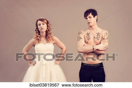 Stock Photo - "Wedding picture, bride and groom, bare chested groom with tattoos and a cigarette". Fotosearch