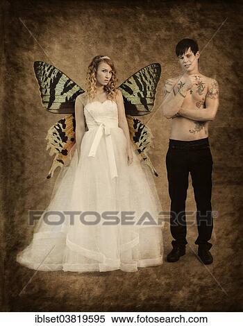 Stock Photography - "Wedding picture, bride and groom, bride with butterfly wings and a bare chested groom with tattoos, holding a cigarette". Fotosearch