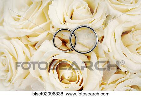 Stock Photo - "Wedding rings on a bridal bouquet, white roses". Fotosearch