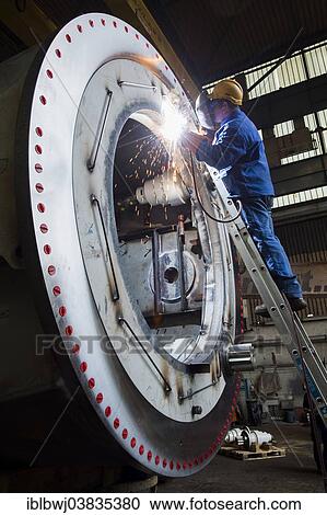 "Welder working at Neunfelder Maschinenfabrik, NMF, production of heavy duty cranes for ships, Hamburg, Germany, Europe" View Large Photo Image Stock Image - "Welder working at Neunfelder Maschinenfabrik, NMF, production of heavy duty cranes for ships, Hamburg, Germany, Europe". Fotosearch
