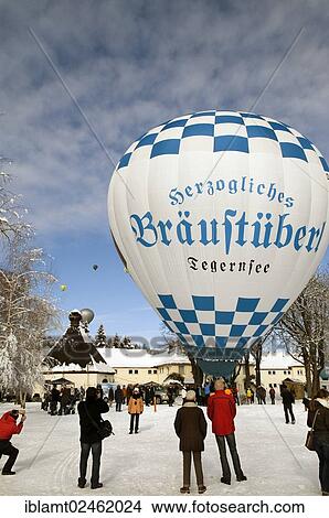 Picture - "White and blue hot air balloon with advertising of """"Herzogliches Braeustuebel"""" restaurant, just before the take-off, Tegernsee Montgolfiade 2012, Bad Wiessee, Tegernsee, Bavaria, Germany, Europe". Fotosearch