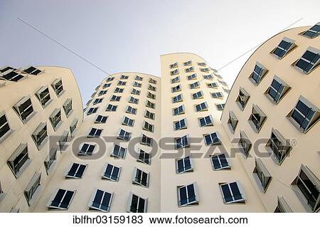 "White office building with slanted windows, Duesseldorf, Medienhafen, media harbour, building by Frank O. Gehry, Dusseldorf, Rhineland, North Rhine-Westphalia, Germany, Europe" View Large Photo Image Stock Image - "White office building with slanted windows, Duesseldorf, Medienhafen, media harbour, building by Frank O. Gehry, Dusseldorf, Rhineland, North Rhine-Westphalia, Germany, Europe". Fotosearch