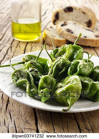 Stock Image - Whole griddled Padron peppers with sea salt. Fotosearch