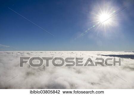 Stock Image - "Wind turbines covered by low clouds, blue sky, aerial view, Marsberg, Sauerland region, North Rhine-Westphalia, Germany, Europe". Fotosearch