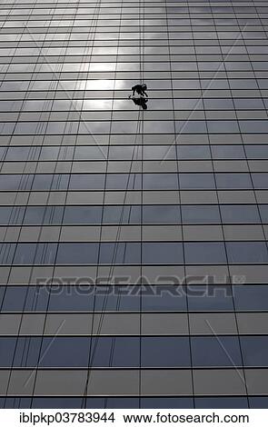 Picture - Window cleaner cleaning a window pane. Fotosearch