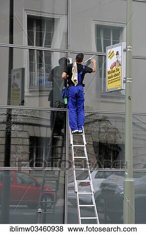 "Window cleaner standing on a ladder cleaning a glass facade, next to advertising sign """"Wollen Sie nach oben? """", German for """"do you want to climb the social ladder""""?, Berlin, Berlin, Germany, Europe" View Large Photo Image Stock Photo - "Window cleaner standing on a ladder cleaning a glass facade, next to advertising sign """"Wollen Sie nach oben? """", German for """"do you want to climb the social ladder""""?, Berlin, Berlin, Germany, Europe". Fotosearch