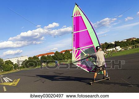 "Windskater practicing on the asphalt runway with a windsurfer sail and a longboard, Berlin-Tempelhof, Tempelhofer Feld, Berlin, Berlin, Germany, Europe" View Large Photo Image Stock Photo - "Windskater practicing on the asphalt runway with a windsurfer sail and a longboard, Berlin-Tempelhof, Tempelhofer Feld, Berlin, Berlin, Germany, Europe". Fotosearch