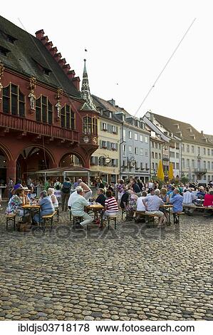 "Wine stand and restaurants in front of the Historical Merchants Hall on Muensterplatz square or Cathedral Square, Freiburg im Breisgau, Baden-Wurttemberg, Germany, Europe" View Large Photo Image Stock Photo - "Wine stand and restaurants in front of the Historical Merchants Hall on Muensterplatz square or Cathedral Square, Freiburg im Breisgau, Baden-Wurttemberg, Germany, Europe". Fotosearch