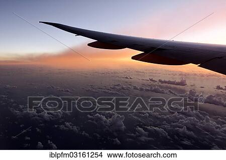 Wing of a high flying Boeing 777 long reach aircraft at sunset View Large Photo Image Picture - Wing of a high flying Boeing 777 long reach aircraft at sunset. Fotosearch