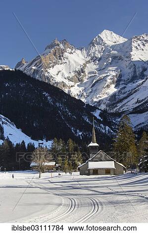 Picture - "Winter landscape with cross-country skiers, Blueemlisalp Massif in the middle, St. Mary's Church, Bernese Alps, Kandersteg, Canton of Bern, Switzerland, Europe". Fotosearch