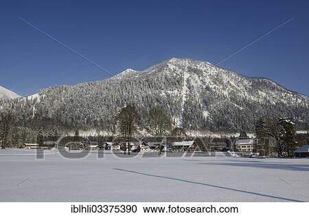 Stock Image - "Winter morning in the village of Walchensee, Mount Herzogstand at back, Walchensee, Upper Bavaria, Bavaria, Germany, Europe". Fotosearch