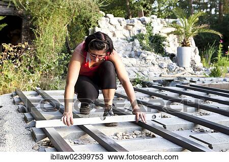 "Woman, 40, using a spirit level during the construction of a patio, Austria, Europe" View Large Photo Image Stock Image - "Woman, 40, using a spirit level during the construction of a patio, Austria, Europe". Fotosearch