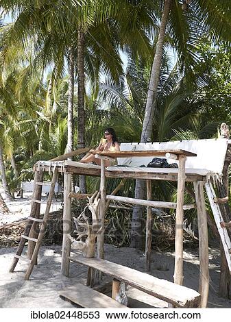 "Woman, 45, drinking a cocktail on a raised seat at a beach bar under palm trees, Playa Samara, Nicoya Peninsula, Costa Rica, Central America, North America" View Large Photo Image Stock Image - "Woman, 45, drinking a cocktail on a raised seat at a beach bar under palm trees, Playa Samara, Nicoya Peninsula, Costa Rica, Central America, North America". Fotosearch