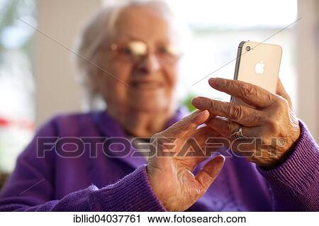"Woman, 87 years, holding a mobile phone, in a nursing home" View Large Photo Image Stock Image - "Woman, 87 years, holding a mobile phone, in a nursing home". Fotosearch