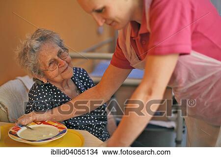 Picture - "Woman, 89 years, at lunch, with geriatric nurse, nursing home". Fotosearch