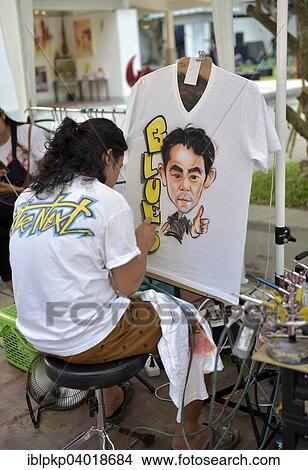 "Woman airbrushing a portrait on a T-shirt, Hua Hin, Thailand, Asia" View Large Photo Image Picture - "Woman airbrushing a portrait on a T-shirt, Hua Hin, Thailand, Asia". Fotosearch