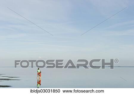 Stock Image - "Woman and child in the mudflats at low tide, Amrum, North Frisian Islands, Schleswig-Holstein, Germany, Europe". Fotosearch