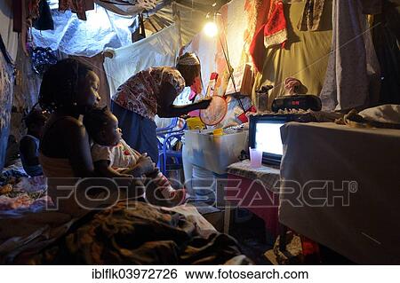 Stock Photograph - "Woman and children in a ramshackle hut, Camp Icare, camp for earthquake refugees, Fort National, Port-au-Prince, Haiti, North America". Fotosearch