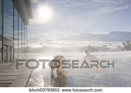 "Woman and man sitting in a heated swimming pool in winter with steaming water, South Tyrol, Trentino-Alto Adige, Italy, Europe" View Large Photo Image Stock Image - "Woman and man sitting in a heated swimming pool in winter with steaming water, South Tyrol, Trentino-Alto Adige, Italy, Europe". Fotosearch