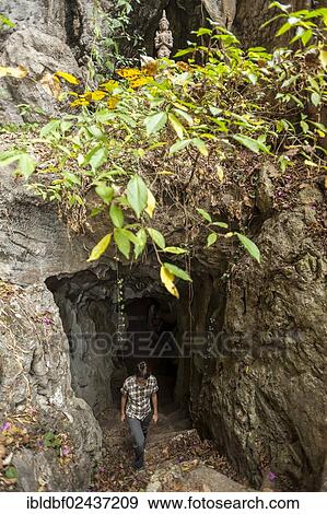 Stock Photo - "Woman at the entrance to the Buddha cave, Mae Cham, Chiang Rai Province, Northern Thailand, Thailand, Asia". Fotosearch
