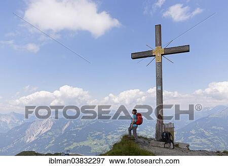 "Woman at the summit cross of the Golmer Joch, Golm, Ratikon, Montafon, Vorarlberg, Austria, Europe" View Large Photo Image Stock Photo - "Woman at the summit cross of the Golmer Joch, Golm, Ratikon, Montafon, Vorarlberg, Austria, Europe". Fotosearch