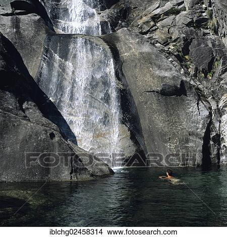 Picture - "Woman bathing at a waterfall, Val Verzasca, Tessin, Swizerland, Europe". Fotosearch