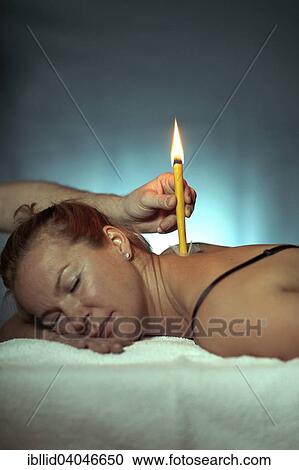 Stock Image - Woman being treated with a body candle. Fotosearch