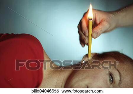 Woman being treated with an ear candle View Large Photo Image Stock Photography - Woman being treated with an ear candle. Fotosearch