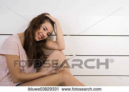Woman chatting at home on a tablet computer View Large Photo Image Stock Image - Woman chatting at home on a tablet computer. Fotosearch
