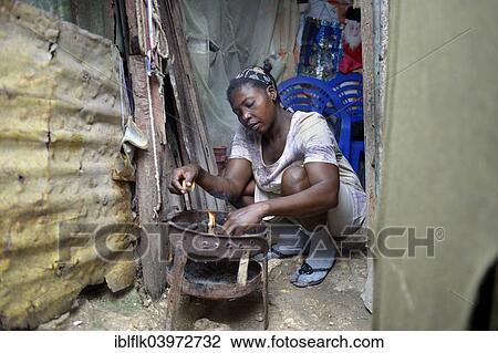 "Woman cooking in the improvised kitchen of an ramshackle hut, Camp Icare, camp for earthquake refugees, Fort National, Port-au-Prince, Haiti, North America" View Large Photo Image Stock Image - "Woman cooking in the improvised kitchen of an ramshackle hut, Camp Icare, camp for earthquake refugees, Fort National, Port-au-Prince, Haiti, North America". Fotosearch