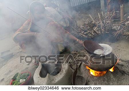"Woman cooking rice on an open fire, face obscured by smoke, Barakandi, Sirajganj, Bangladesh, South Asia, Asia" View Large Photo Image Stock Photograph - "Woman cooking rice on an open fire, face obscured by smoke, Barakandi, Sirajganj, Bangladesh, South Asia, Asia". Fotosearch