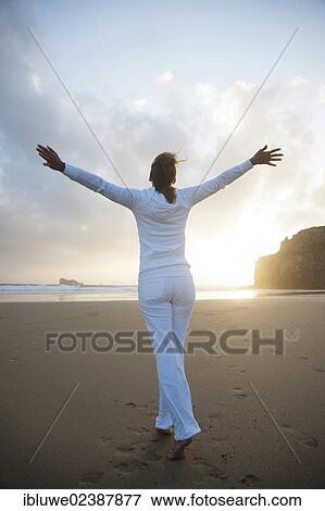 Woman doing relaxation exercises on a beach at sunset View Large Photo Image Stock Photo - Woman doing relaxation exercises on a beach at sunset. Fotosearch