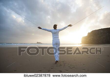 Woman doing relaxation exercises on a beach at sunset View Large Photo Image Stock Photo - Woman doing relaxation exercises on a beach at sunset. Fotosearch