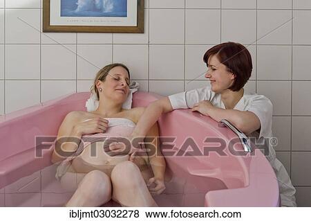 "Woman during childbirth in a birthing bath in the maternity delivery room beside her midwife, Germany, Europe" View Large Photo Image Stock Photo - "Woman during childbirth in a birthing bath in the maternity delivery room beside her midwife, Germany, Europe". Fotosearch