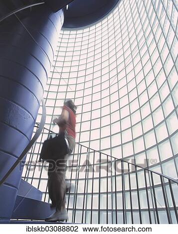 Woman going up the stairs of a staircase with glass blocks View Large Photo Image Stock Image - Woman going up the stairs of a staircase with glass blocks. Fotosearch