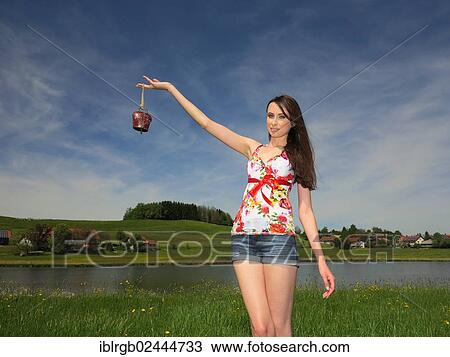 Stock Image - Woman holding a cowbell from Allgaeu. Fotosearch