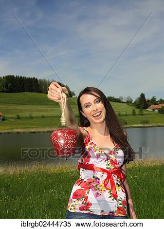 Woman holding a cowbell from Allgaeu View Large Photo Image Stock Photography - Woman holding a cowbell from Allgaeu. Fotosearch