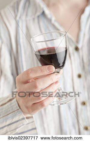 Woman holding a glass of red wine View Large Photo Image Stock Photo - Woman holding a glass of red wine. Fotosearch
