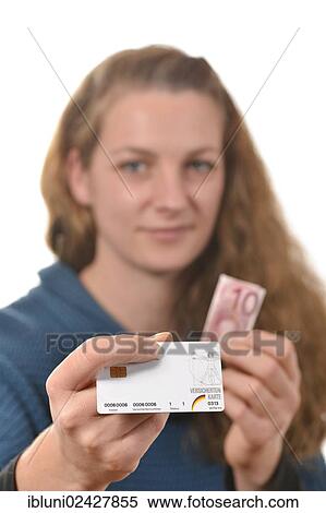 Stock Photography - Woman holding a health insurance card and a 10 euro banknote. Fotosearch